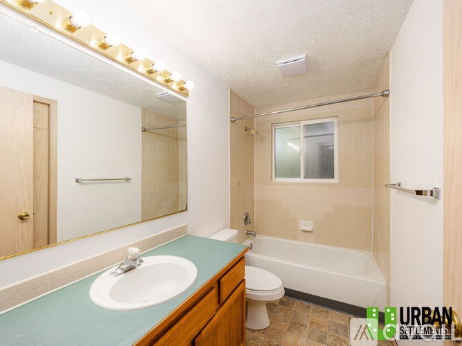 A bathroom with a sink, toilet, and bathtub.