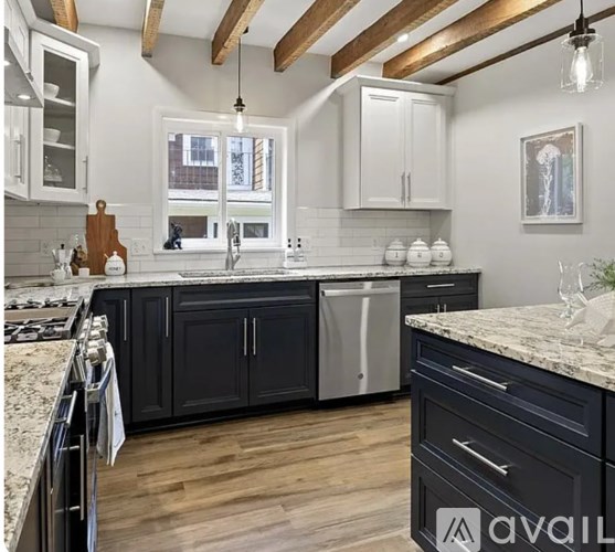 A kitchen with black cabinets and a marble countertop.