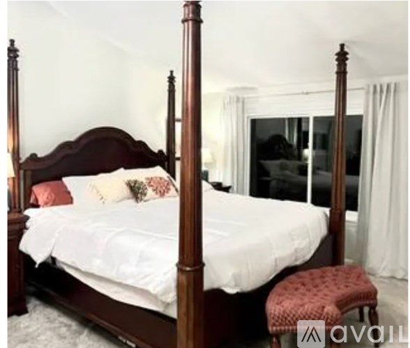 A bed with a wooden frame and four posts is in a room.