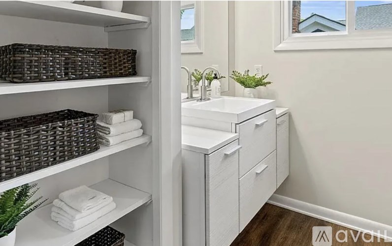 A bathroom with a white cabinet and a window.