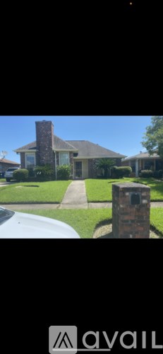 A house with a brick chimney and a driveway.