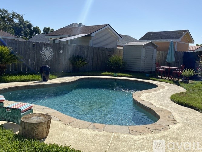 A backyard with a pool and a fence.