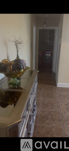A kitchen with a stove top oven and a vase with fruit on a counter.