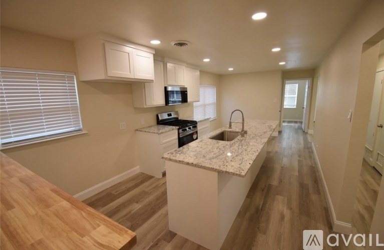 A kitchen with a wooden countertop and a microwave above it.