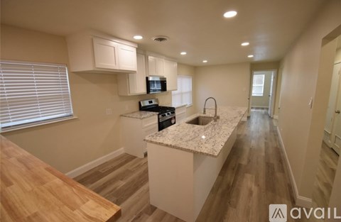 A kitchen with a wooden countertop and a microwave above it.