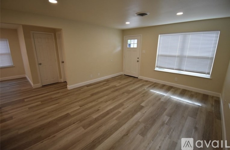 A room with wooden flooring and two doors.