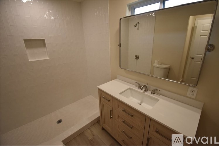 A bathroom with a white sink and a large mirror.
