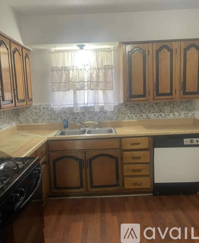A kitchen with wooden cabinets and a black stove top oven.