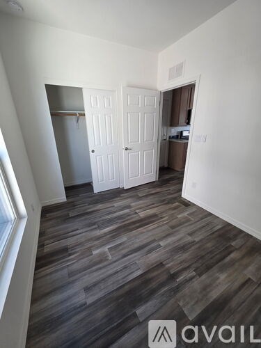 A room with a wooden floor and a white door.