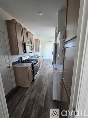 A kitchen with wooden cabinets and a refrigerator.