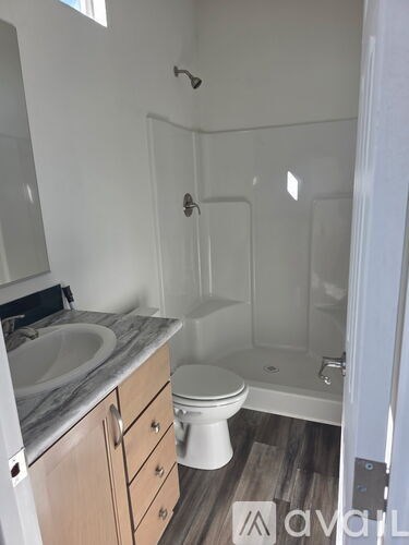 A bathroom with a toilet, sink, and shower.