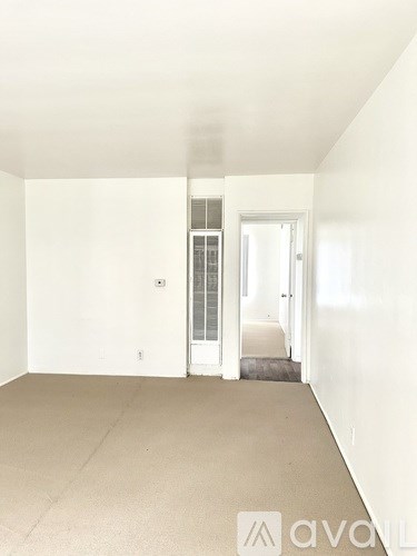 A room with a carpeted floor and a doorway leading to another room.