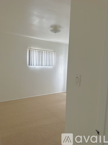 A room with a window and a light switch.