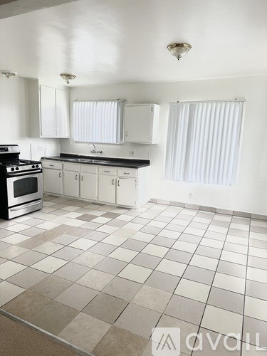 A kitchen with white cabinets and a black stove top oven.