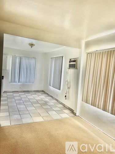 A hallway with a tan carpet and white walls.