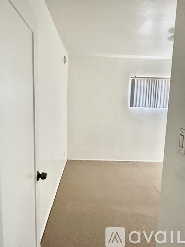 A room with a door and a window with blinds.