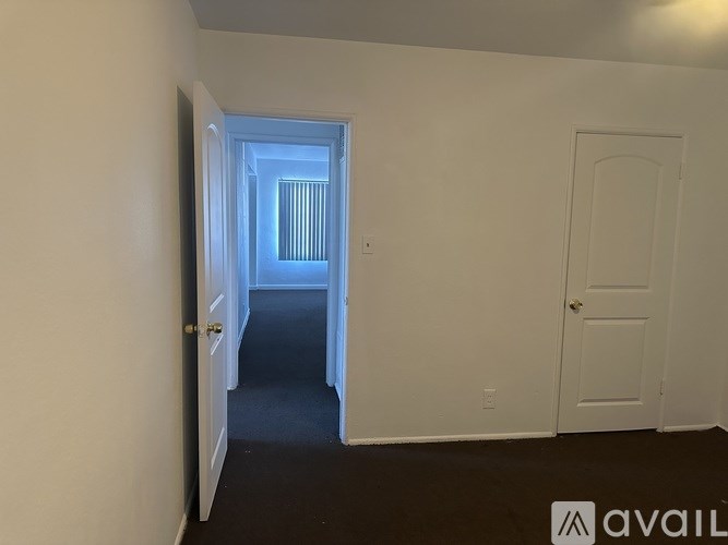 A hallway with a door on the right and a window on the left.