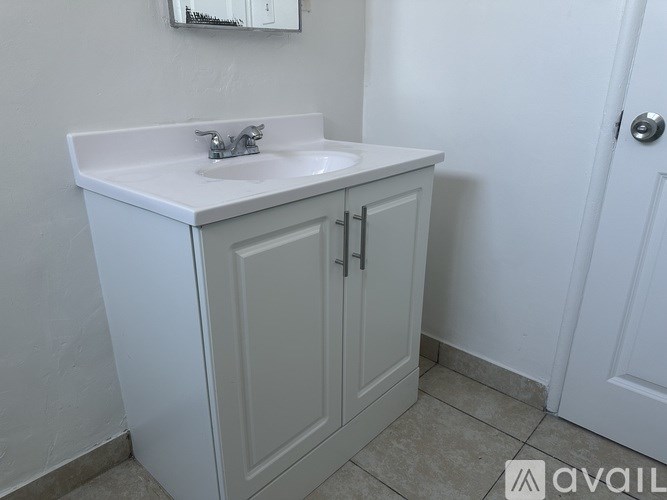 A white bathroom sink with a cabinet below it.
