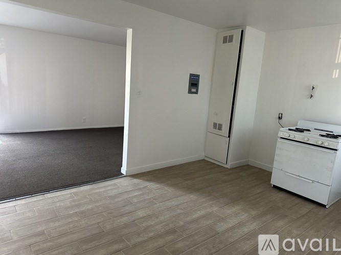 A kitchen area with a stove top oven and a refrigerator.