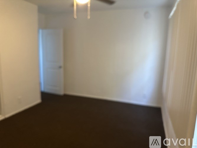 A room with a brown floor and white walls.