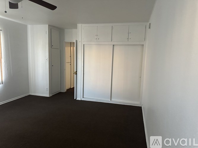 A room with a ceiling fan and sliding doors.