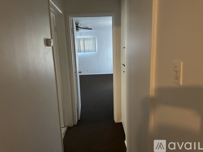 A hallway with a light switch on the wall.