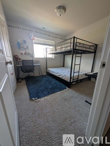 A room with a bunk bed and a desk.