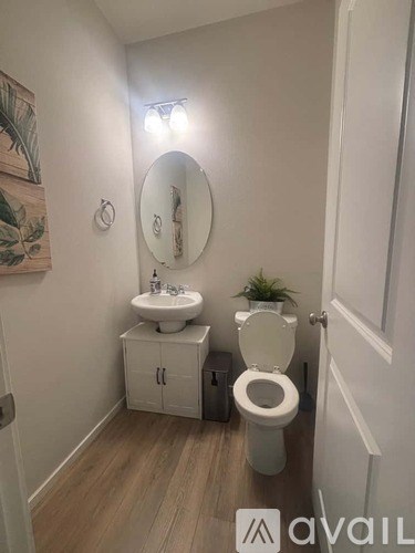 A bathroom with a toilet, sink, and mirror.