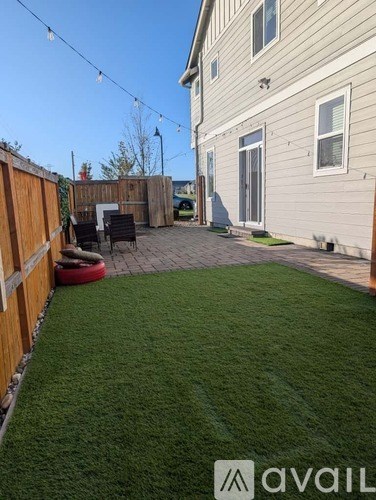 A backyard with a wooden fence and a green lawn.