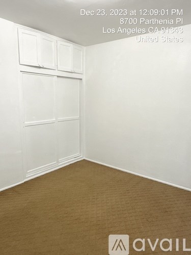 A room with white walls and a wooden floor is available for rent.