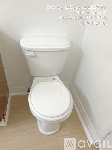 A white toilet in a small bathroom.