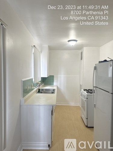 A kitchen with white appliances and a white refrigerator.
