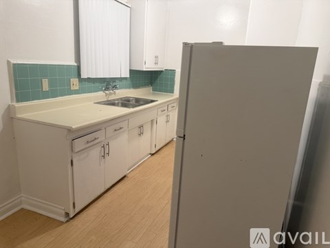 A bathroom with a white tub, sink, and wooden cabinet.
