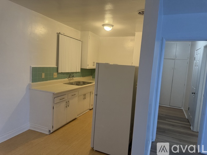 A room with wooden flooring and a window with blinds.