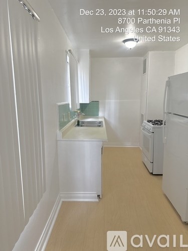 A small white kitchen with a washer and dryer.