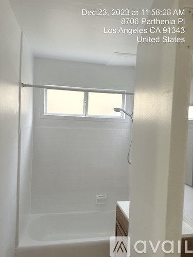 A bathroom with a window and a tub in it.