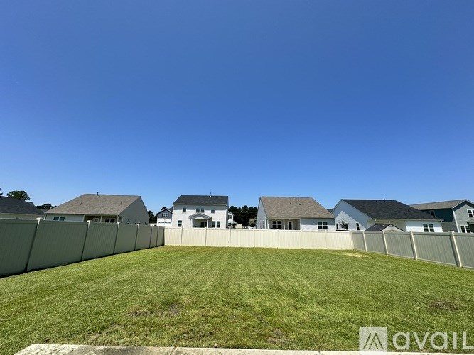 A house with a white fence is for sale.