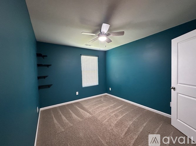 A room with blue walls and a ceiling fan.