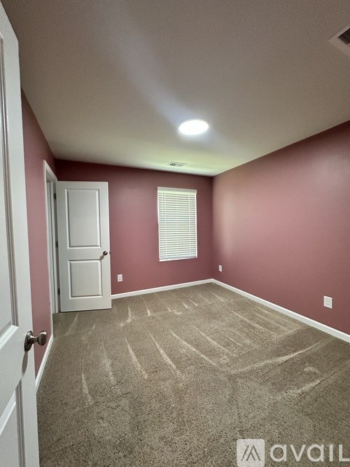 A room with a carpeted floor and a door.