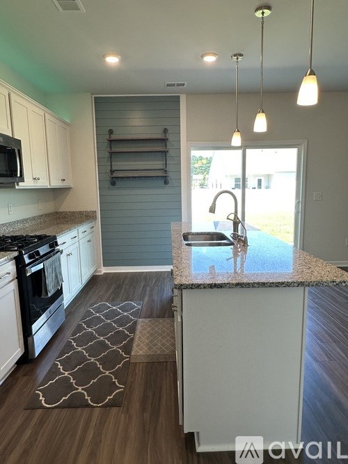 A kitchen with a black stove top oven and white cabinets.