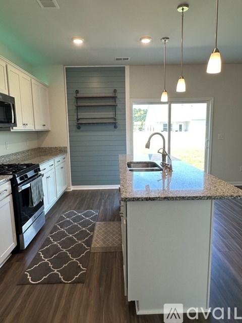 A kitchen with a black stove top oven and white cabinets.