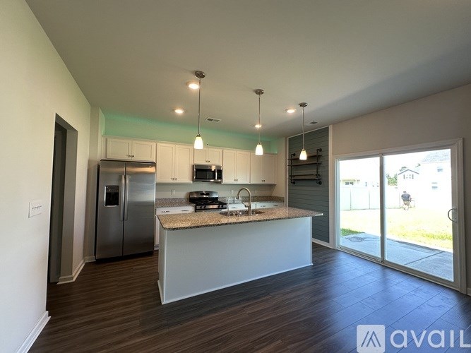 A modern kitchen with stainless steel appliances and a central island.