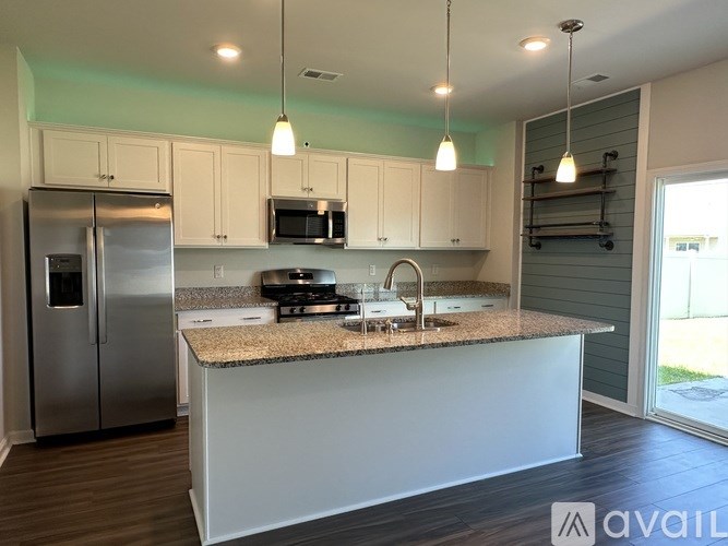 A kitchen with a granite countertop and stainless steel appliances.