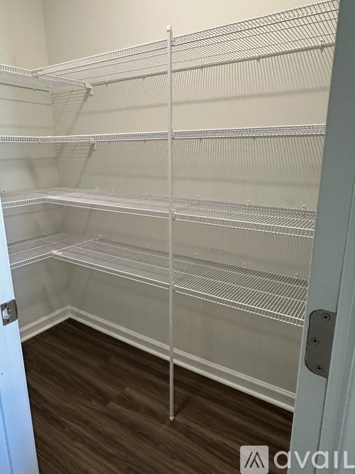 Empty shelves in a room with wooden flooring and white walls.