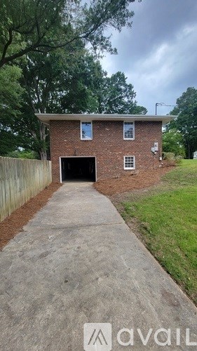 A brick house with a garage door and a driveway leading to it.