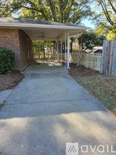 A covered patio area with a concrete floor and a wooden fence.