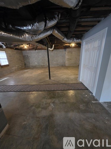 A room with a concrete floor and a door on the right side.