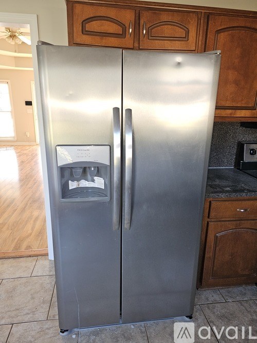 A stainless steel refrigerator with a water and ice maker on the door.