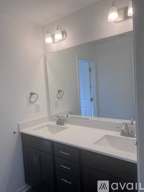 A bathroom with two sinks and a large mirror.