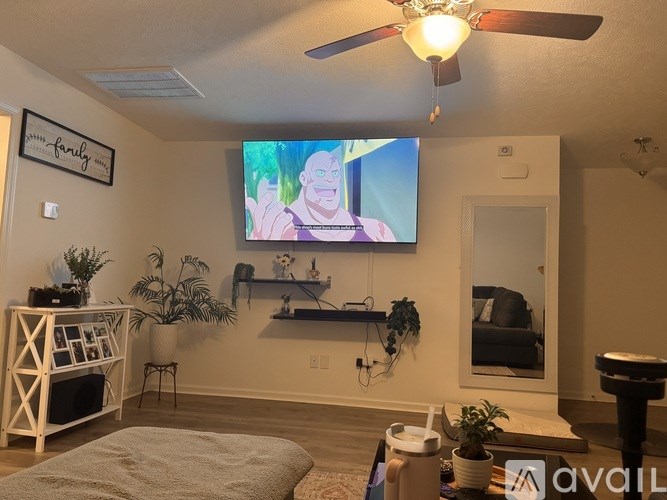 A living room with a flat screen TV mounted on the wall.